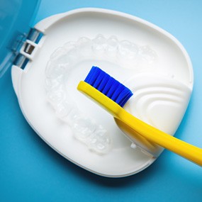 Transparent aligners in a case next to a toothbrush