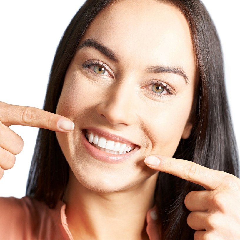 Smiling woman pointing to her teeth